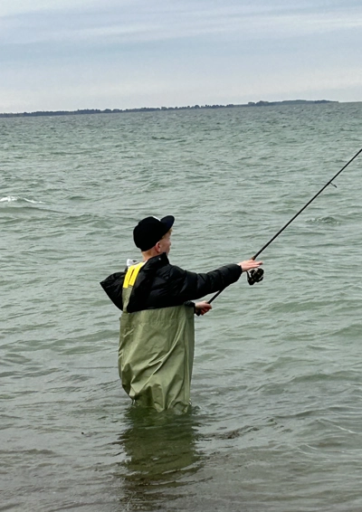Dreng fiske med vaders på