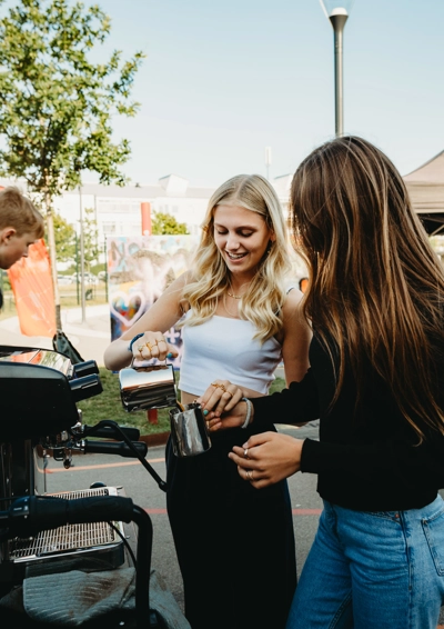 2 unge fritidsjobbere betjener barista kaffemaskinen
