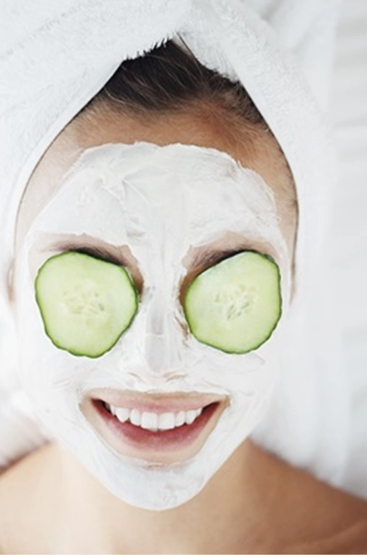 smilede ansigt med ansigtsmaske og agurkeskiver på øjenlåg