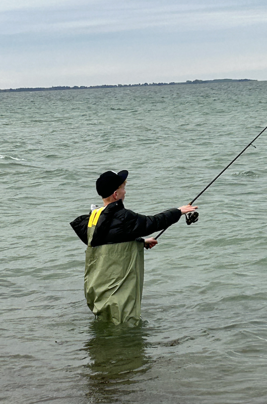 Dreng fiske med vaders på