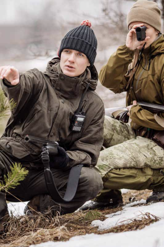 2 personer på jagt siddende med kikkert i hånden