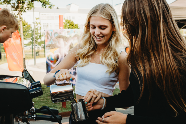 2 unge fritidsjobbere betjener barista kaffemaskinen